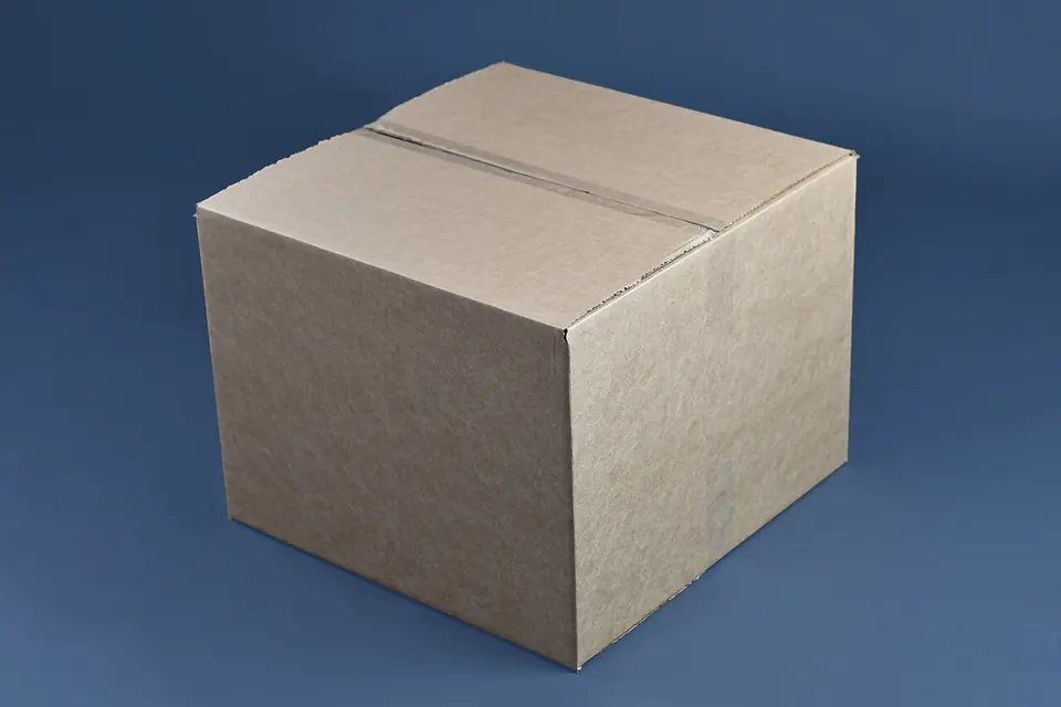 Grand carton de déménagement fermé par du ruban adhésif sur fond gris