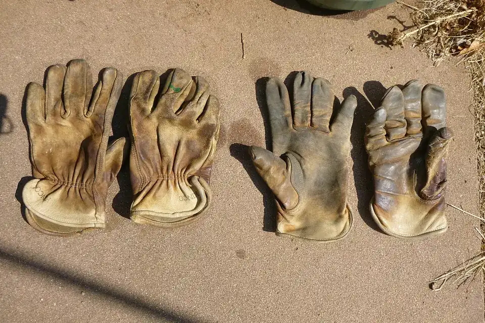 Deux paires de gants de travail en cuir posées côte à côte