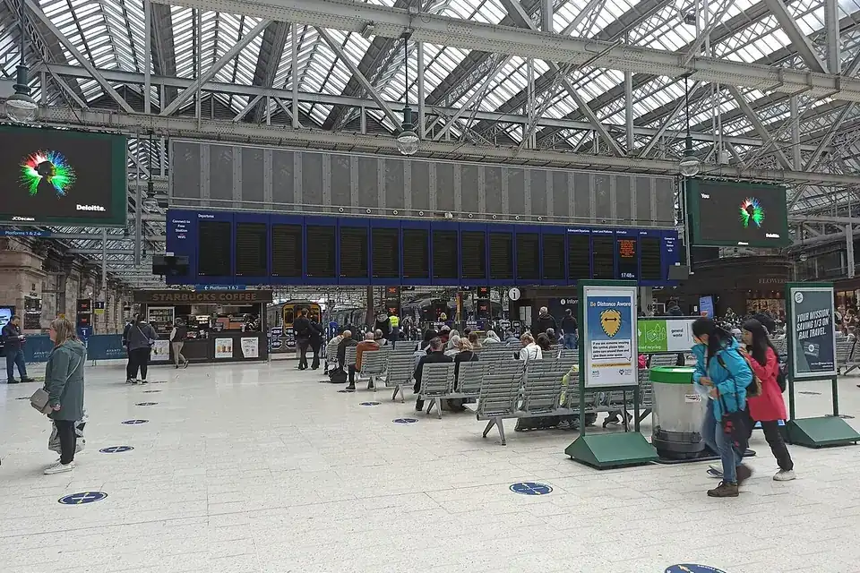 Grand panneau d'affichage des départs dans le hall d'une gare britannique