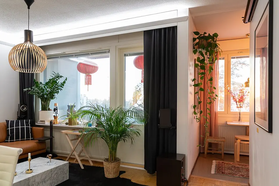 Intérieur d'un petit studio meublé avec un lit, un bureau et une fenêtre lumineuse